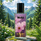 Blissful Blue Lady perfume bottle with pink flowers on label, set on mossy rock in mountain meadow