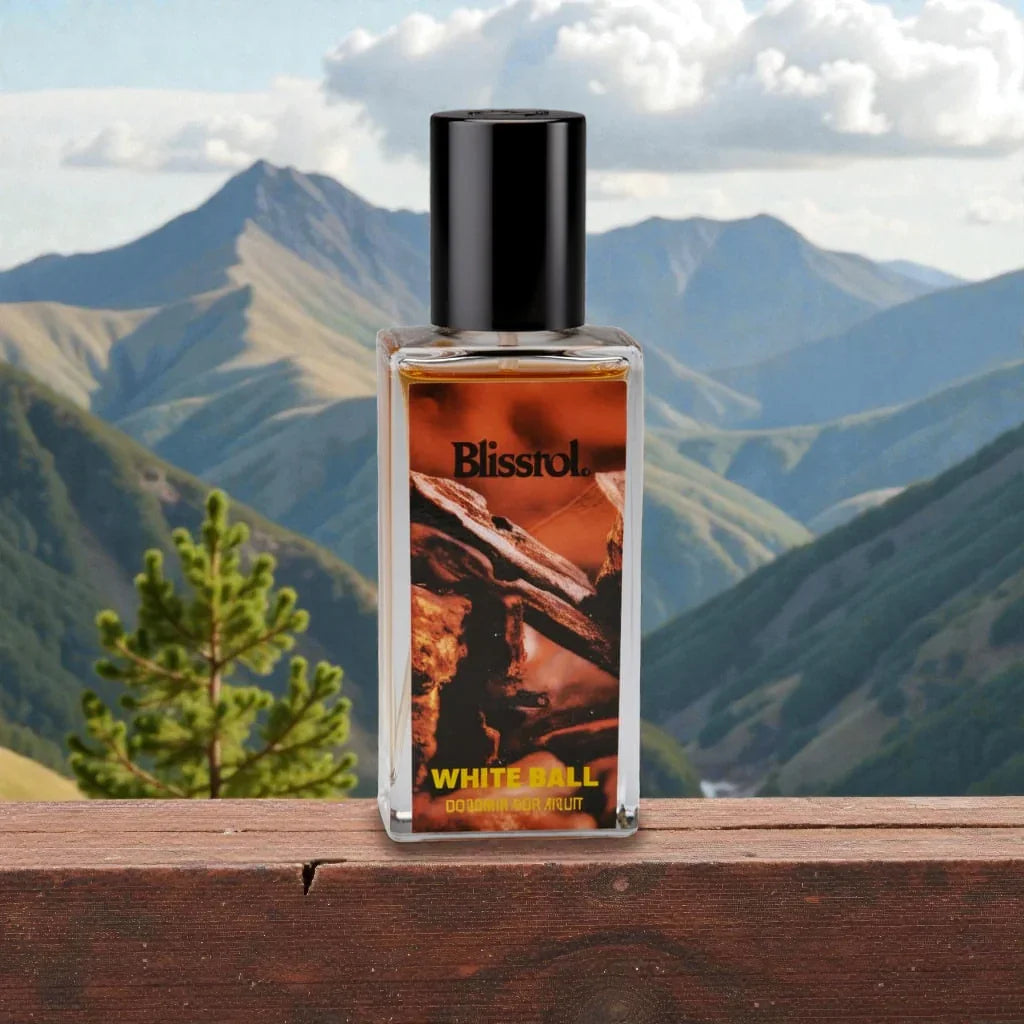 Blisstol White Ball perfume bottle on wooden surface with mountain landscape background