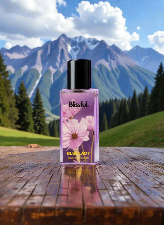 Blissful Blue Lady perfume bottle with pink flowers on wooden surface, mountainous background