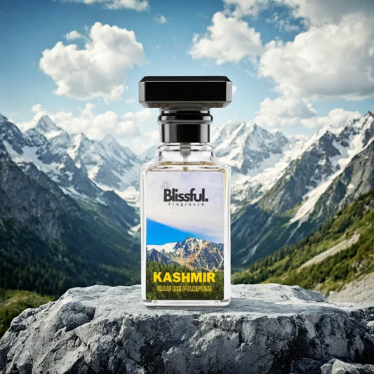 Blissful Kashmir Eau de Parfum bottle on rock with snowy mountain peaks and blue sky background